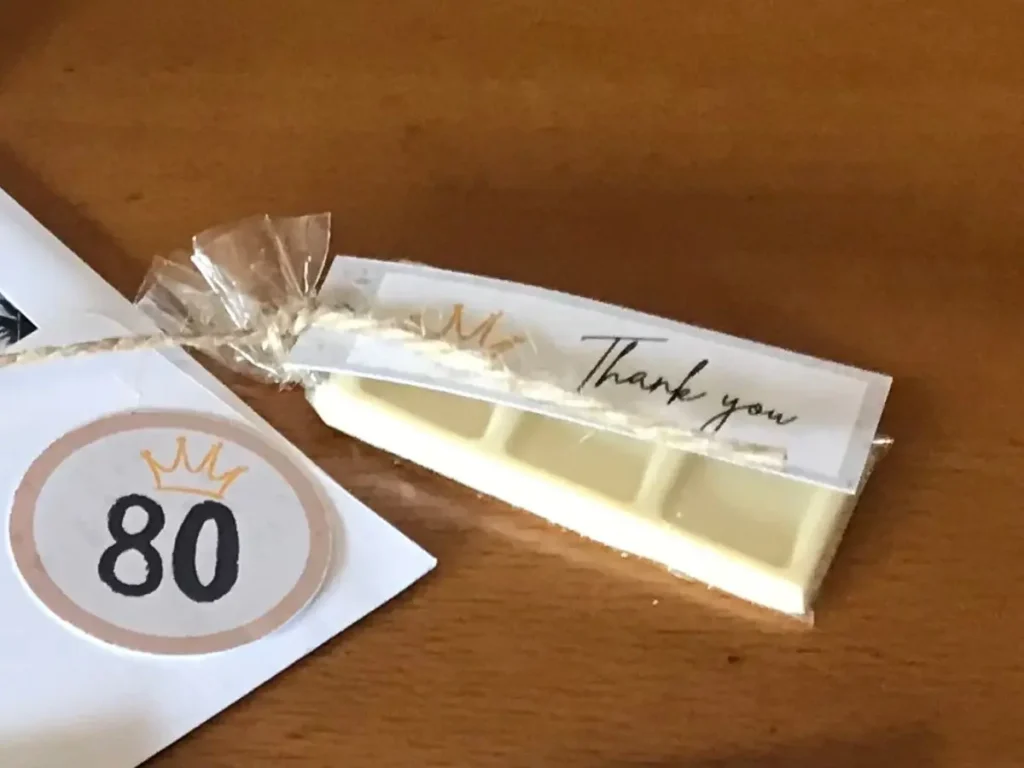 Handmade thank you chocolate favour wrapped in cellophane and tied with twine, featuring a crown-themed thank you label.