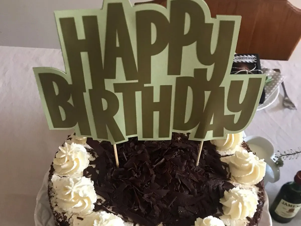 Black Forest birthday cake with cream piping and gold Happy Birthday cake topper for an Ultimate tea party for him
