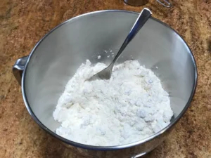 Russian squares recipe dry ingredients flour dried fruit and baking powder mixed in a bowl