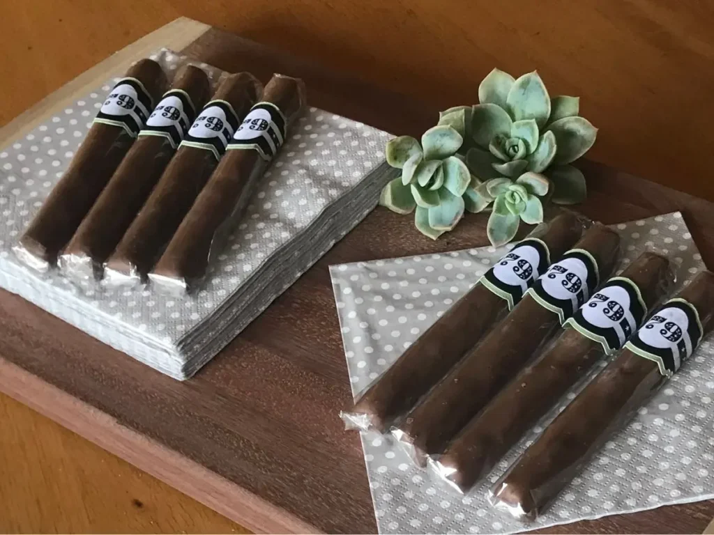 Chocolate cigar party favours displayed on beige polka dot napkins for a grown-up celebration