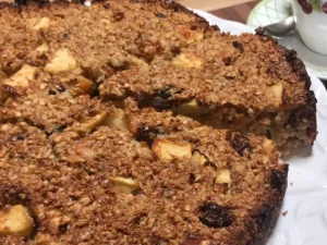 Oats and apple breakfast cake with slice lifted on cake lifter