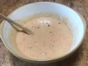 Mixed carrot cake batter with grated carrots and pineapple