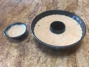 Carrot cake batter poured into a greased bundt cake pan before baking