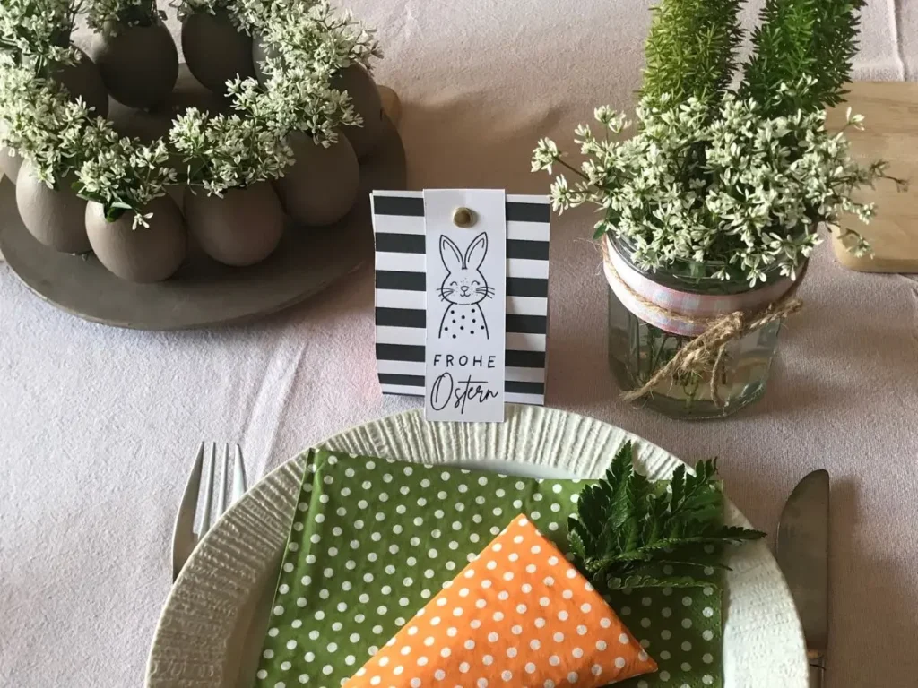 Simple Easter table with egg wreath centrepiece, folded napkins and floral touches