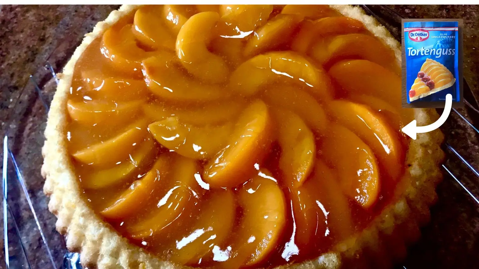 Homemade peach flan topped with glossy peach slices and a shiny clear glaze (Tortenguss)