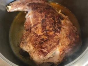 Leg of lamb browning in a pot with oil