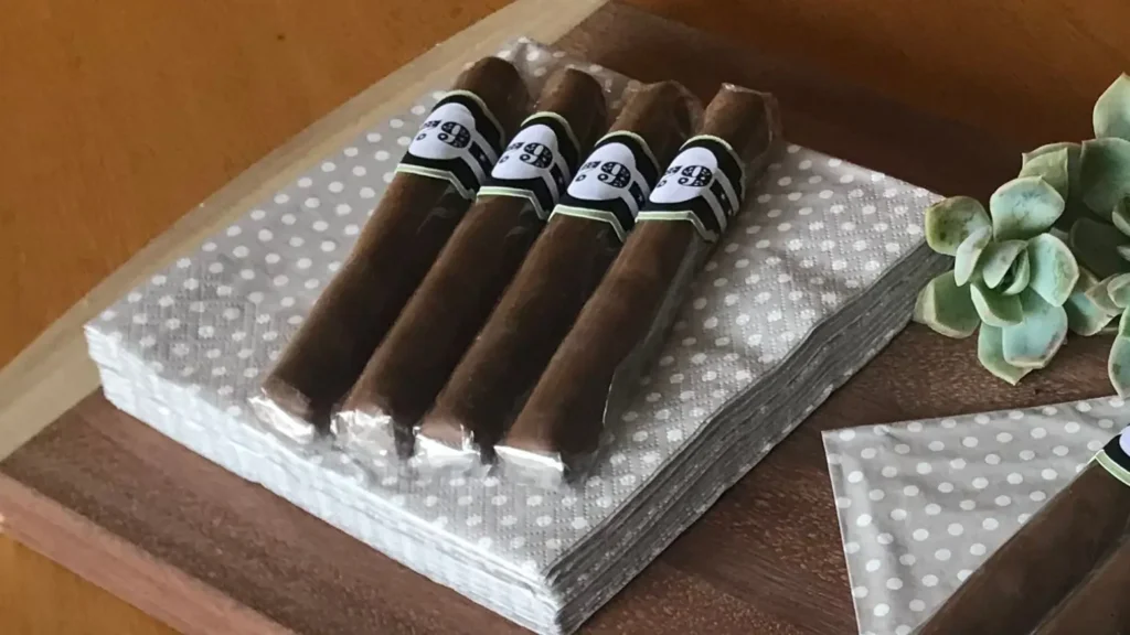 Chocolate cigar party favours displayed on beige polka dot napkins for a grown-up celebration