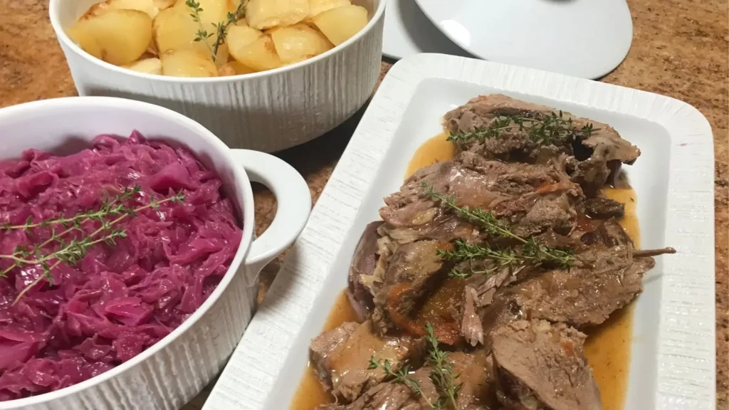 Leg of lamb pot roast served with red cabbage and roast potatoes