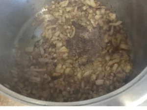 Onions and gravy mixture cooking in pot for lamb