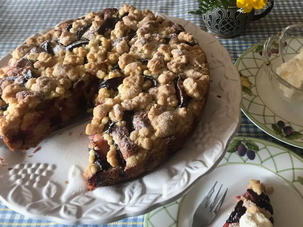 German plum cake with streusel topping dusted with powdered sugar