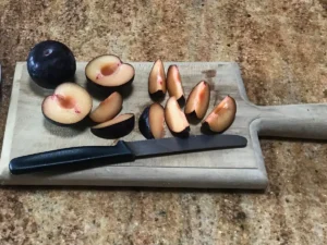 Fresh plums halved and pitted for German plum cake