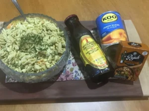 Curried pasta salad with peaches served alongside canned peaches, chutney and curry powder