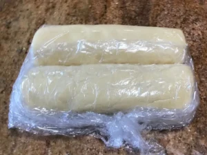 Cookie dough shaped into logs and wrapped in plastic wrap